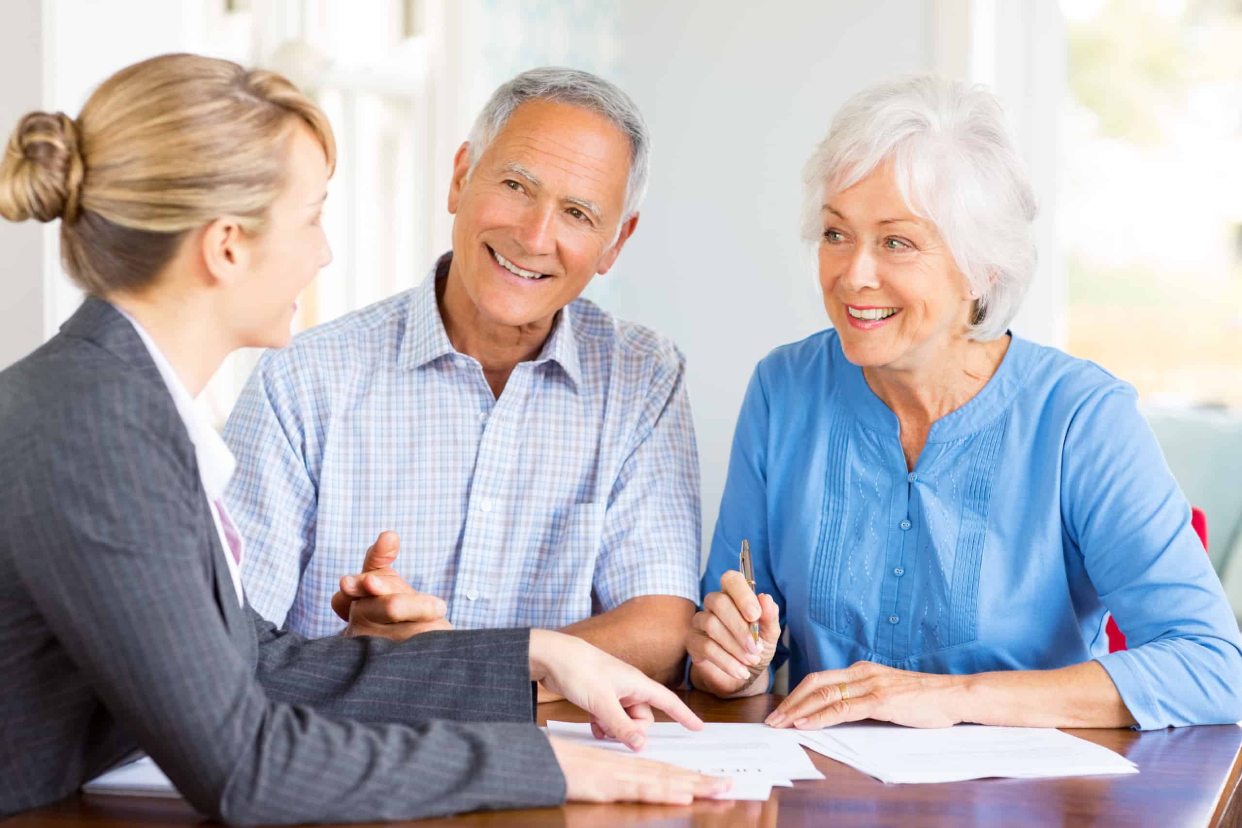 Happy Senior Couple With Financial Adviser At Home