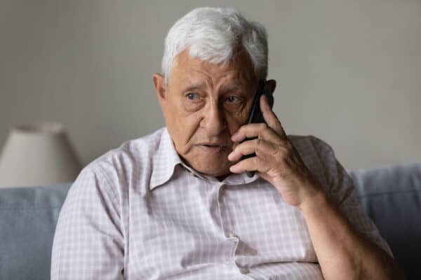 Man worriedly talks on phone about affordable cremation