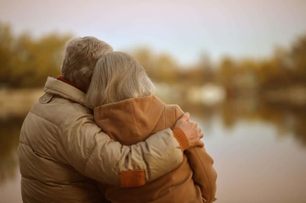 couple hug while looking at natural setting