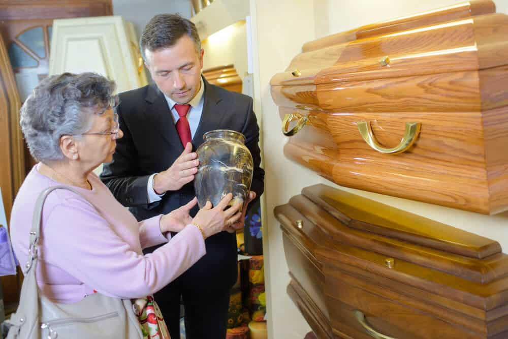 A cremation provider showing an older woman an urn