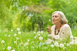 Older woman with dandelions - green funeral services.