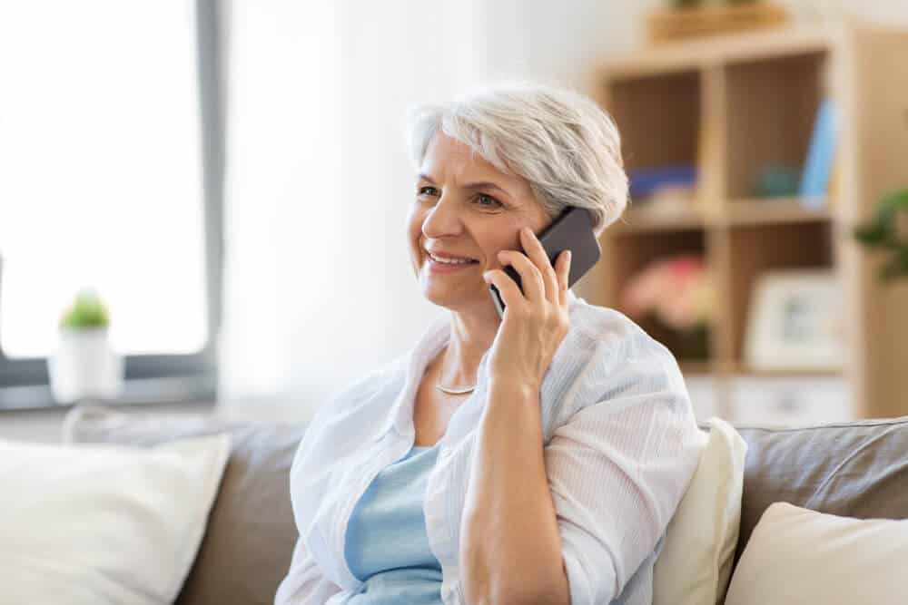 Woman talks with cremation provider on phone to make end of life plans.