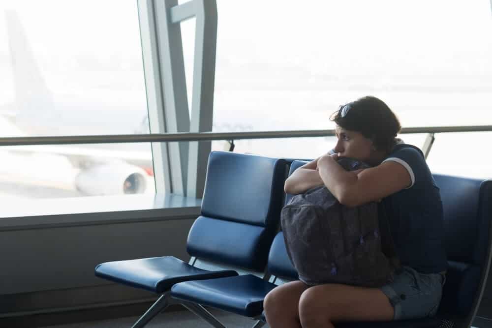 Woman contemplates dead body flight cost.